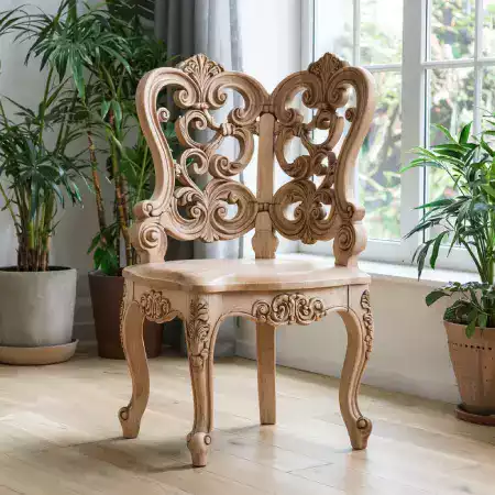 Lakshmi Devi applying third coat of natural teak oil finish to carved wooden table using soft cloth in Bangalore workshop